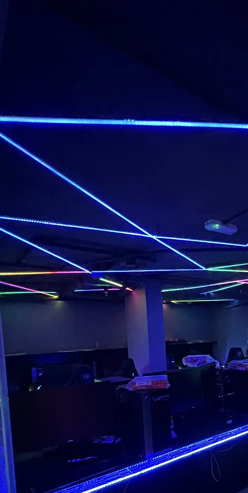 Gaming venue ceiling LED geometry and desk-edge RGB strip